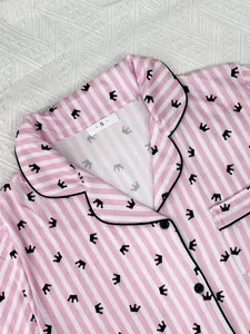 Vue détaillée d'un haut de pyjama rose rayé avec motif couronne et revers.