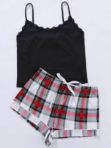 Detail van een zwarte camisole top met kant en een geruite pyjamashort set voor dames