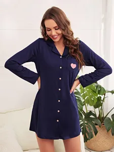 Détail de la chemise de nuit bleu marine à manches longues avec cœur rose sur la poche