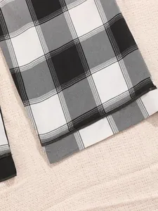 Close-up view of black and white checkered pajama pants showing the hem stitching detail