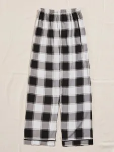Detailed view of women's black and white plaid pajama pants with elastic waistband