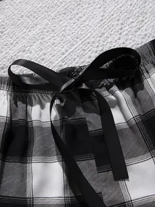 Detailopname van een zwart-wit geruite pyjamashort met een schattige satijnen strik