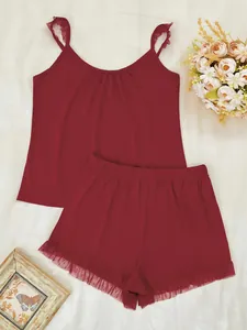 Détail de l'ensemble pyjama bordeaux pour femme avec bordure en dentelle et volants.