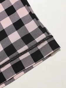 Close-up detail of pink and black plaid pajama pants fabric and stitching