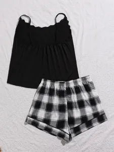 Detail van grote maat pyjamaset met zwart kanten hemdje en geruite shorts in buffalo plaid.