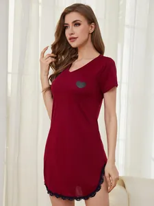 Detail view of a burgundy women's nightdress with heart print and black lace trim.