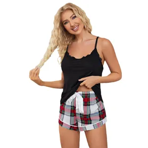 Women's two-piece pajama set with black lace camisole and plaid shorts on white background