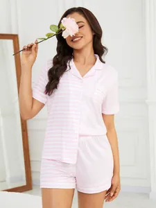 Model wearing a pink and white striped pajama set holding a rose in a home setting