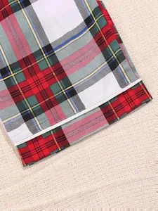 Close-up detail of a classic red and green plaid pattern on soft pajama pants hem