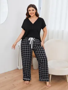 Detailed view of women's plus size pajama set featuring black top and plaid pants.