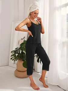 Dettaglio del set pigiama nero da donna con finiture in pizzo e pantaloni capri