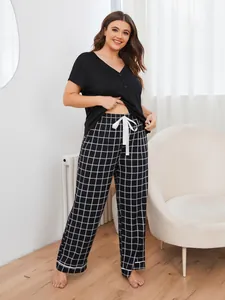 Plus size women's pajama set featuring black short sleeve top and grid pattern pants