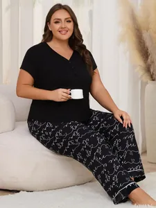 Detailed shot of plus size black pajama set featuring white cursive love print pants
