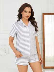 Elegant women's grey and white striped short-sleeved pajama set in a bedroom setting