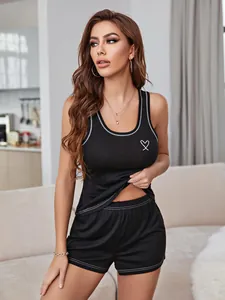 Close-up detail of women's black leisure pajama set with white heart print detail.