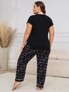 Back view of women's plus size black sleepwear set featuring script printed pants