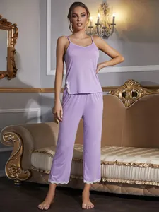Vista completa di una donna in pigiama viola con bordo in pizzo in una stanza classica