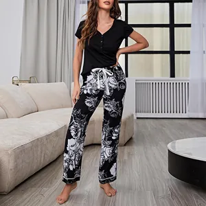 Women's two-piece short sleeve pajama set with black top and elegant floral pants
