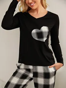 Close-up of black long-sleeve pajama top with heart-shaped plaid patch detail