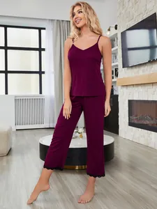 Dettaglio dell'elegante set pigiama color prugna con bordi in pizzo nero sui pantaloni