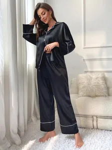 Elegant black satin pajama set for women featuring long sleeves and piped trim details
