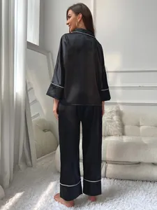 Detailed back view of black silk satin pajamas set with elegant white piping for women