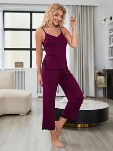 Elegante set pigiama bordeaux con canotta, pizzo nero e pantaloni lunghi indossato dalla modella