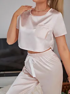 Close-up of a pink satin pajama set featuring a short-sleeved top and ribbon pants