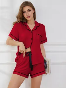 Detailansicht eines roten kurzärmeligen Pyjama-Sets mit schwarzer Paspelierung.