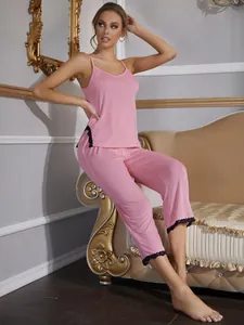 Donna con set pigiama rosa con canotta e pantaloni con bordo in pizzo nero