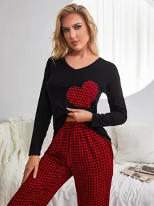 Women's cozy lounge pajama set featuring black heart patch top and red plaid pants