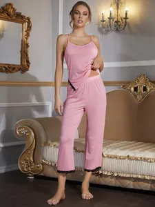 Elegante set pigiama rosa due pezzi con delicato bordo in pizzo nero su top e pantaloni