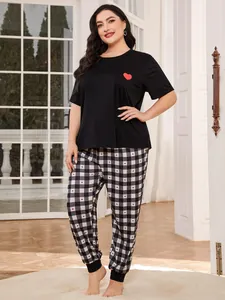 Detailed view of women's plus size pajama set with red heart print and plaid pants