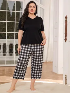 Detail view of plus size pajama set with black V-neck top and checkered heart print pants
