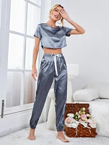 Two-piece satin pajama set featuring a short sleeve crop top and elastic jogger pants