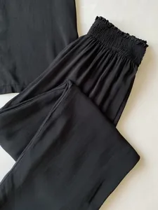 Detail der elastischen Taille und glatten Stoffstruktur der schwarzen Schlafhose