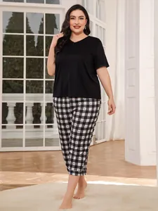 Full view of plus-size black pajama top paired with checkered heart-printed pants