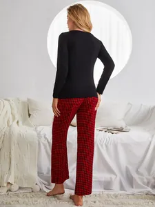 Back view showing the fit of a black long sleeve top and red checkered pajama pants