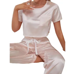 Detail view of a pink satin pajama set featuring a short-sleeved top and joggers