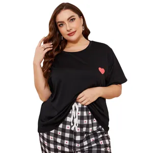 Detail of plus size women's black pajama set featuring heart print and plaid pants