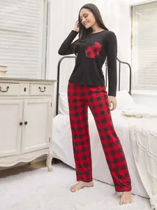 Stylish women's two-piece loungewear set with black heart-patch top and red plaid pants