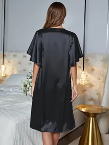 Rear view of a elegant black satin nightgown for women in a cozy bedroom setting