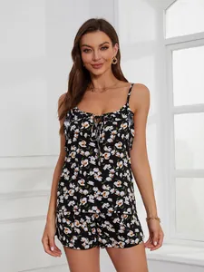 Detailed view of women's black floral camisole pajama top with ruffle trim and drawstring