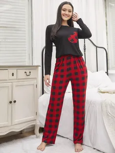 Detailed view of women's buffalo plaid heart pajama set in a cozy bedroom setting