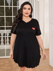Detail view of plus size black nightdress featuring red heart print and elegant lace hemline