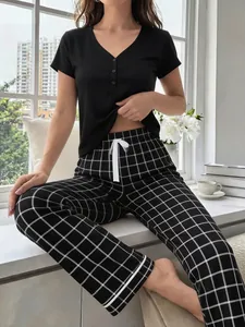 Close-up of women's black short-sleeve top and plaid pajama pants loungewear set