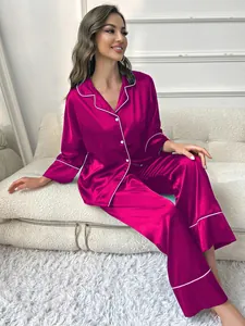 Close-up detail of fuchsia satin pajamas showing elegant fabric luster and white piping