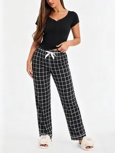 Women's two-piece pajama set with black short sleeve top and plaid long lounge pants