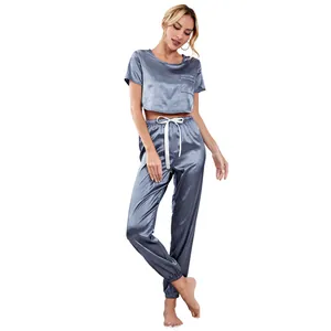 Two-piece satin pajama set with crop top and jogger pants in elegant grey blue