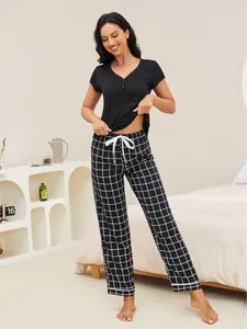 Close-up detail of women's black short-sleeved pajama set featuring stylish plaid pants